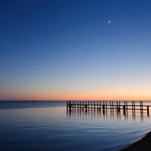 A boat, pier and the moon at dusk - shark bay, monkey mia, western australia.